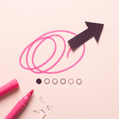 A pink marker loop scribble with a plum paper arrow breaking out of it