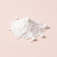 Soft white caprylic acid powder on blush-oat